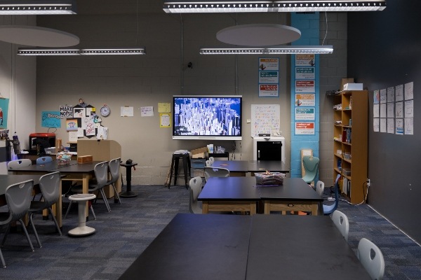 IVA High classroom with large tables and chairs and smartboard