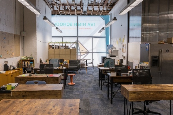 The front office desks of IVA High. The image shows many desks in a room with windows at the end.