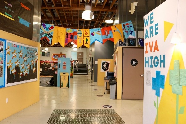 A brightly colored hallway at IVA High is festooned with flags and student decorated walls. 